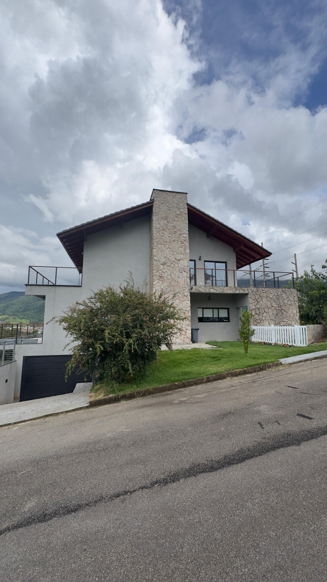 Residência com fachada em pedra e cobertura de madeira, obra conduzida pela Integra Engenharia